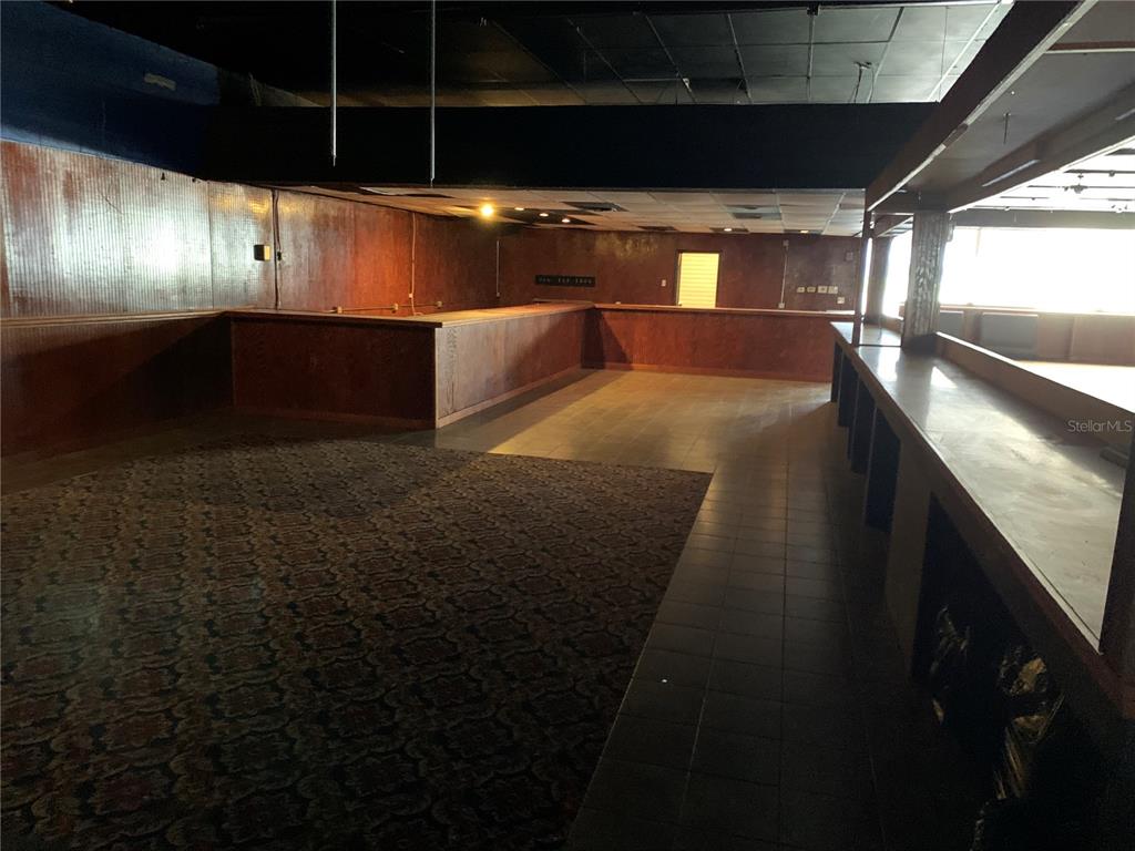 An interior view of a commercial space featuring a long wooden bar and carpeted flooring — 2911 NE JACKSONVILLE ROAD, OCALA, FL
