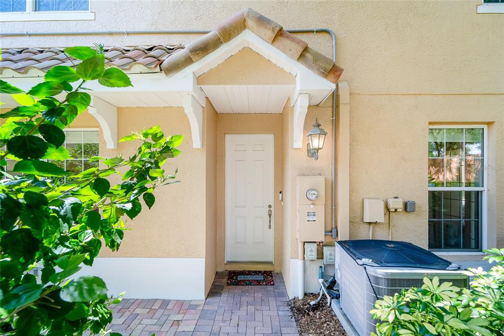 The exterior entrance features a white door, a small tiled roof, and an air conditioning unit — 191 BANYAN BAY DRIVE, ST PETERSBURG, FL