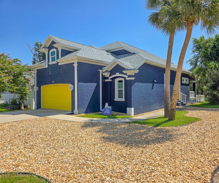 A blue house with a bright yellow garage door and a gravel front yard — 2733 S DAYTONA AVENUE, FLAGLER BEACH, FL