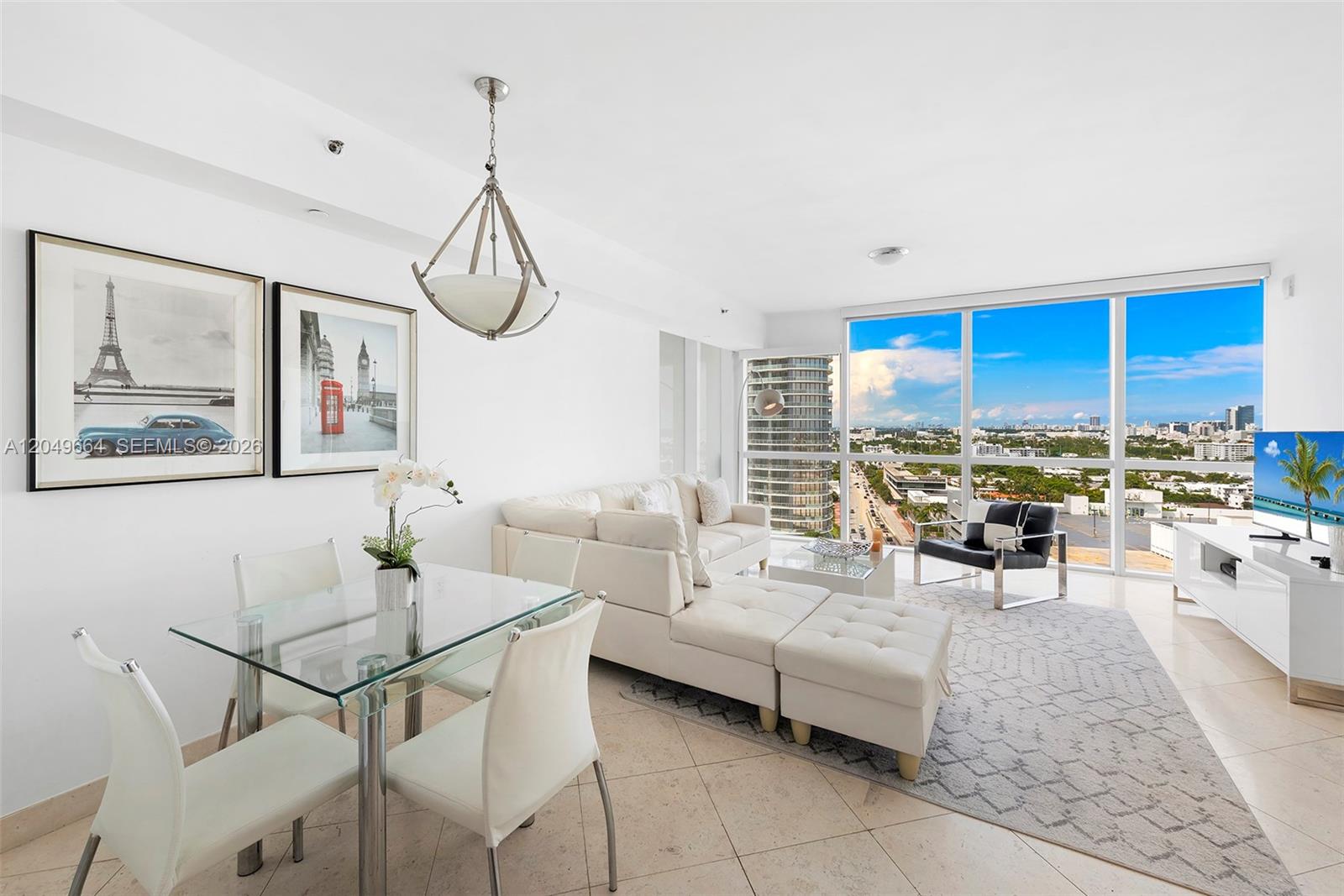 A modern living and dining area features white furniture, a glass table, and floor-to-ceiling windows — 450 Alton Rd # 1708, Miami Beach FL 33139, MIAMI BEACH, FL