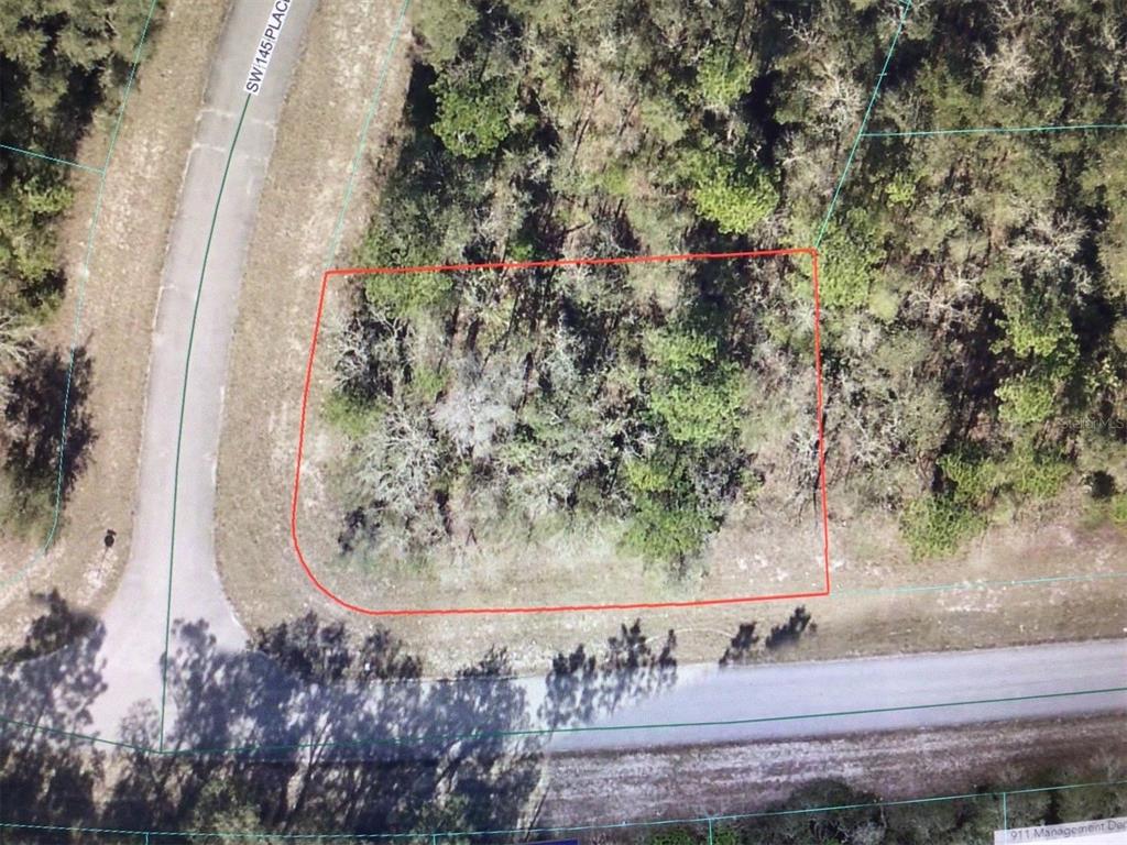 An aerial view shows a wooded, rectangular vacant lot outlined in red near a road — 0 SW 145 PLACE ROAD, OCALA, FL