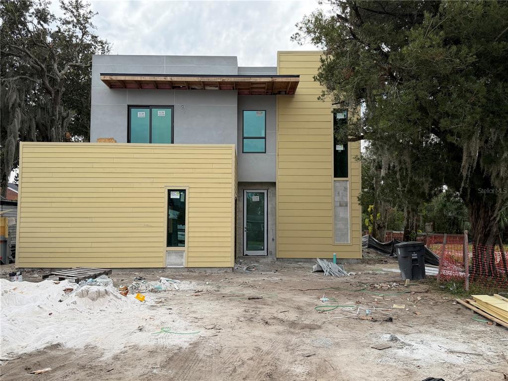 A modern two-story house under construction features yellow horizontal siding and gray stucco walls — 1840 ANZLE AVENUE, WINTER PARK, FL