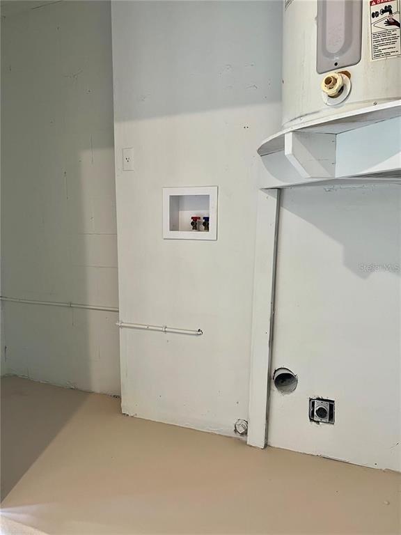A utility room features a water heater, laundry hookups, and an electrical outlet on white walls — 10376 RIVA RIDGE TRAIL, ORLANDO, FL