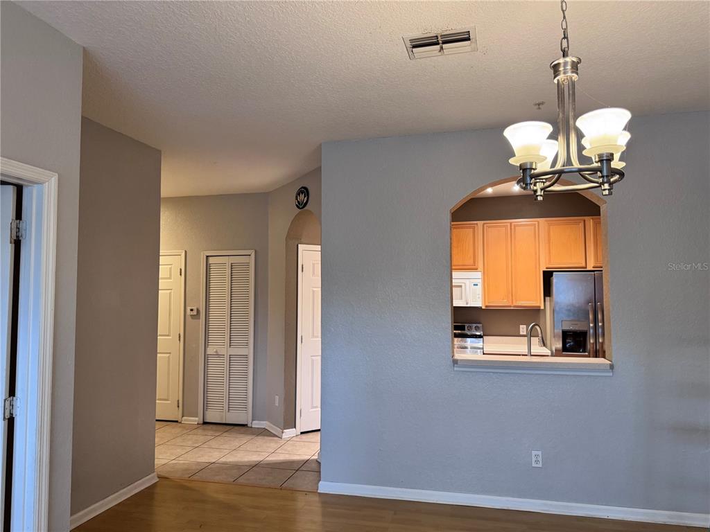A view from a living area looking toward a kitchen pass-through and hallway — 586 BRANTLEY TERRACE WAY UNIT 301, ALTAMONTE SPRINGS, FL