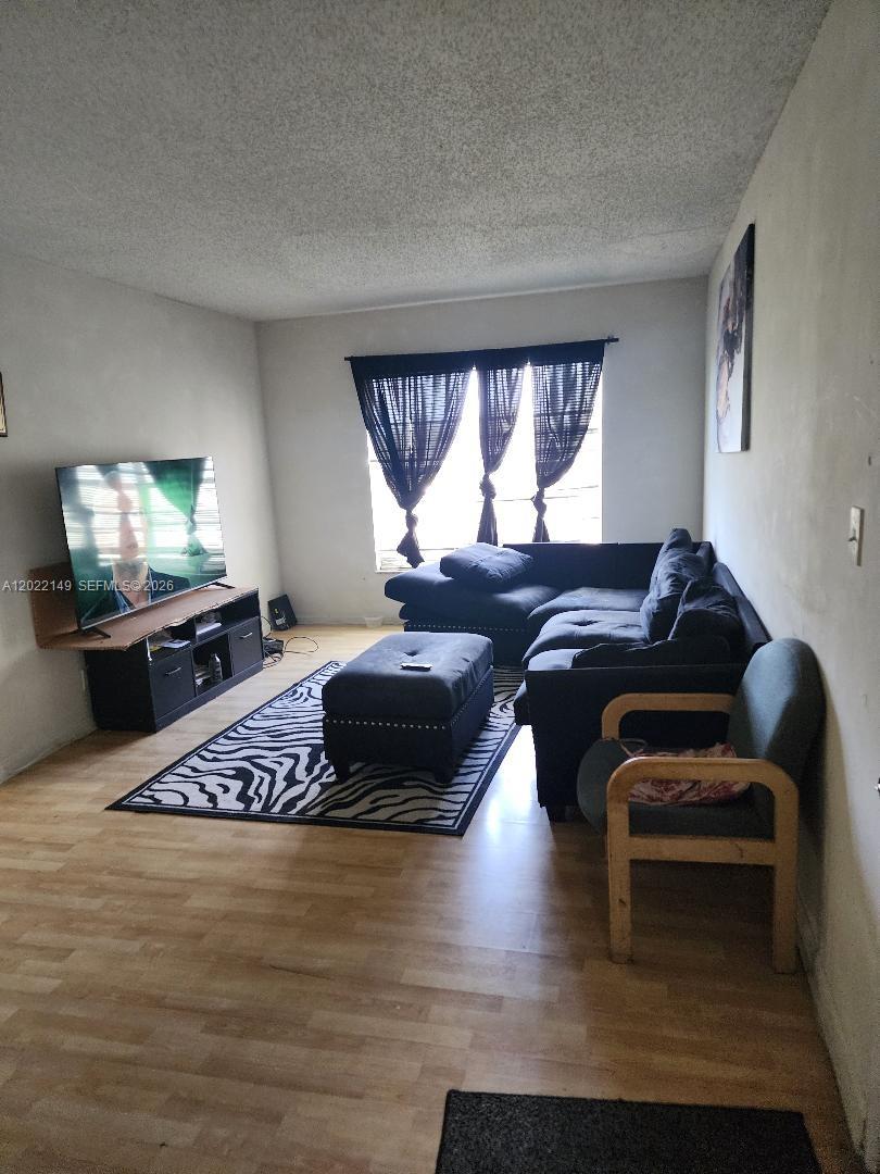A living room features light wood flooring, a dark sectional sofa, and a zebra-print rug — 1331 S Dixie Hwy # 316, Deerfield Beach FL 33441, DEERFIELD BEACH, FL