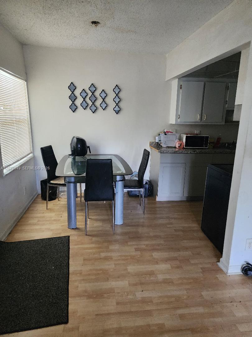 A dining area features a glass-top table, four black chairs, and light wood-look flooring — 1331 S Dixie Hwy # 316, Deerfield Beach FL 33441, DEERFIELD BEACH, FL