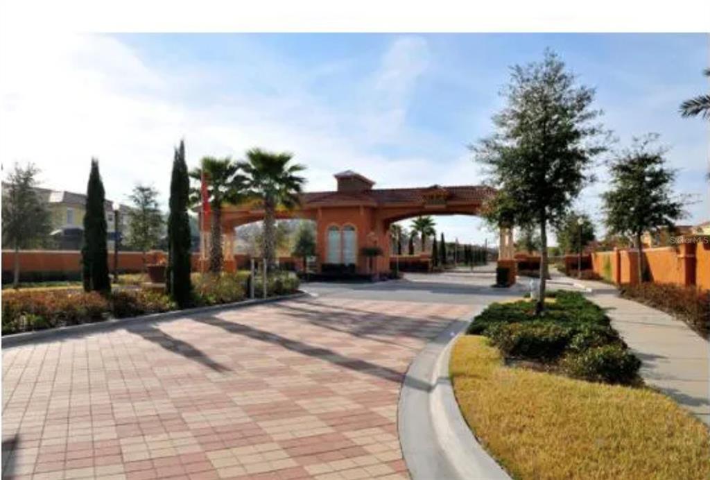 A paved driveway leads to the gated entrance of a residential community with palm trees — 890 MARCELLO BOULEVARD, KISSIMMEE, FL