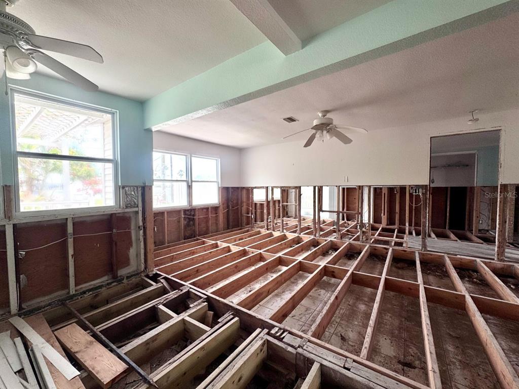 An interior view of a house under renovation with exposed floor joists and wall studs — 202 12TH AVENUE, INDIAN ROCKS BEACH, FL