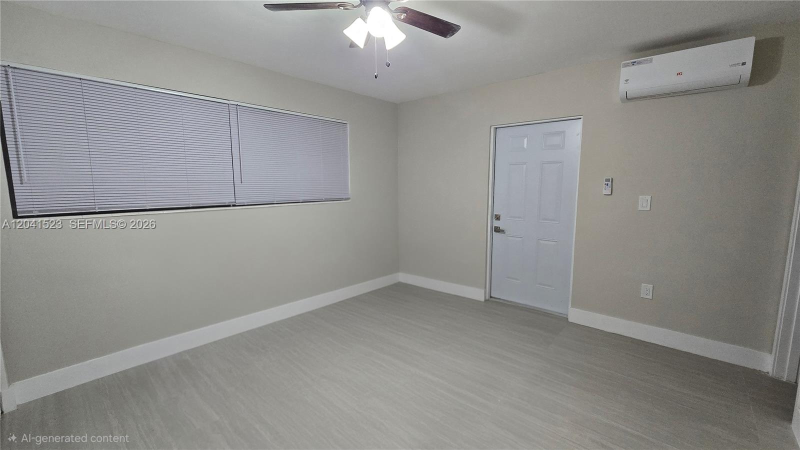 This room features light-colored wood-look flooring, a ceiling fan, a white door, and a wall-mounted air conditioner — MIAMI, FL
