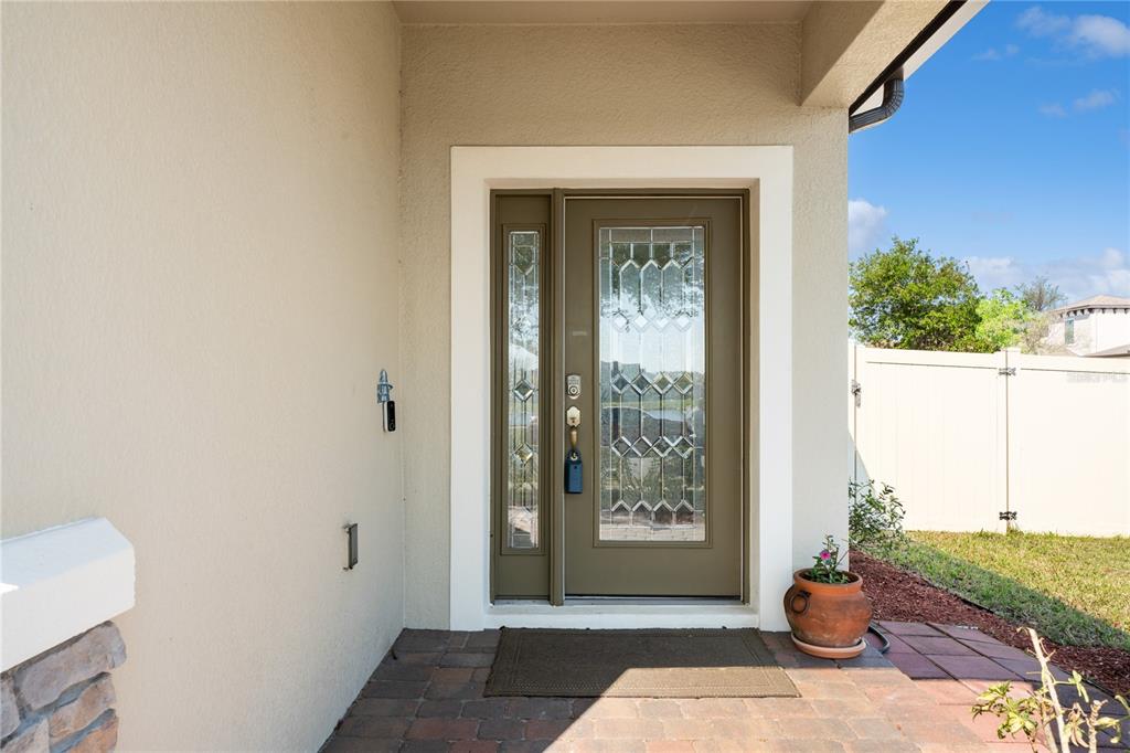 A front entryway features a brown door with glass panels and a side light — 1110 UMBRIA LANE, ST CLOUD, FL