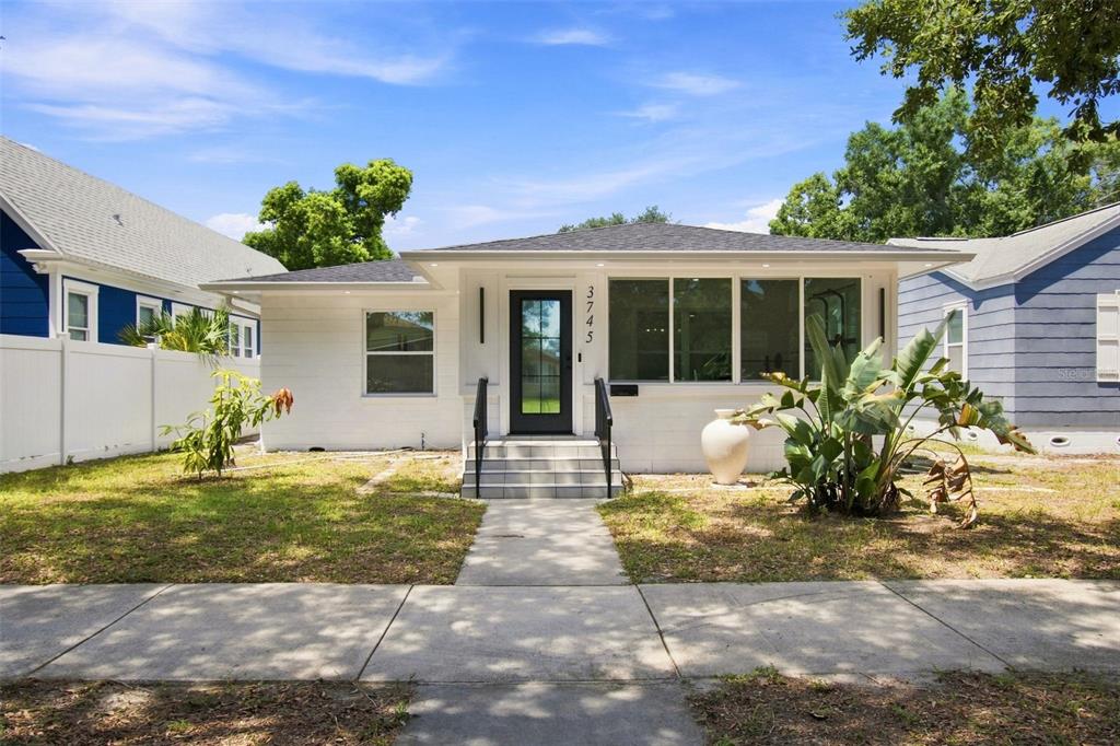 A white, single-story house with a black front door, large windows, and a front walkway — 3745 1ST AVENUE N, ST PETERSBURG, FL