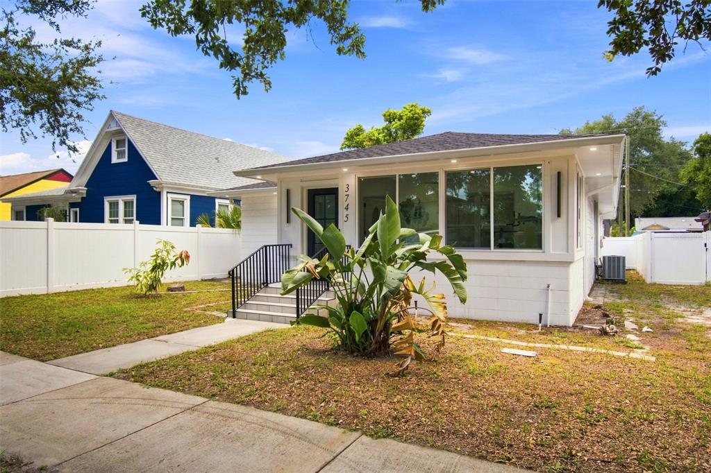 A white, single-story house with a large front window and a small porch with stairs — 3745 1ST AVENUE N, ST PETERSBURG, FL