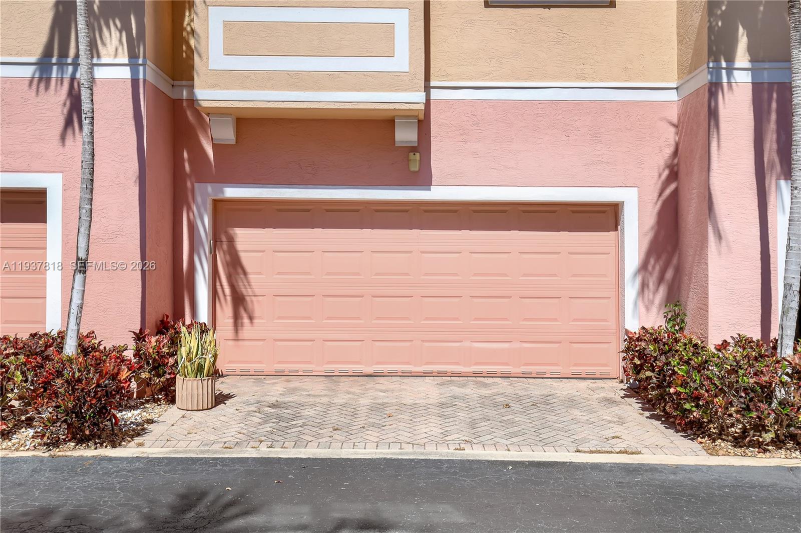 A pink garage door is centered on the exterior wall of a multi-story building — 104 Harbors Way, Boynton Beach FL 33435, BOYNTON BEACH, FL