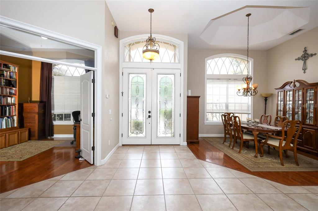 A tiled entryway leads to a dining room with hardwood floors and a double-door entrance — 5695 POND PINE POINT, OVIEDO, FL