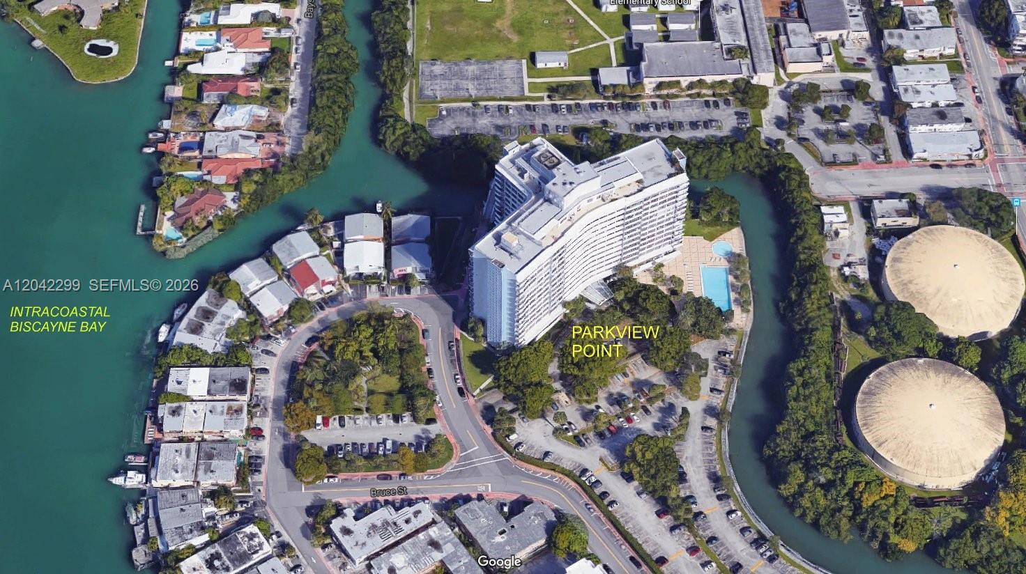 An aerial view of a high-rise apartment building surrounded by a canal and parking lots — 7441 Wayne Ave # 15i, Miami Beach FL 33141, MIAMI BEACH, FL