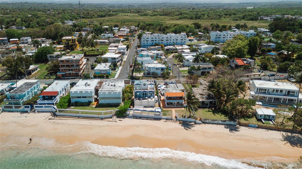 An aerial view of beachfront houses along a sandy coastline with a residential neighborhood behind — Carr. 690 LOTE #5 BO. CERRO GORDO, VEGA ALTA, PR