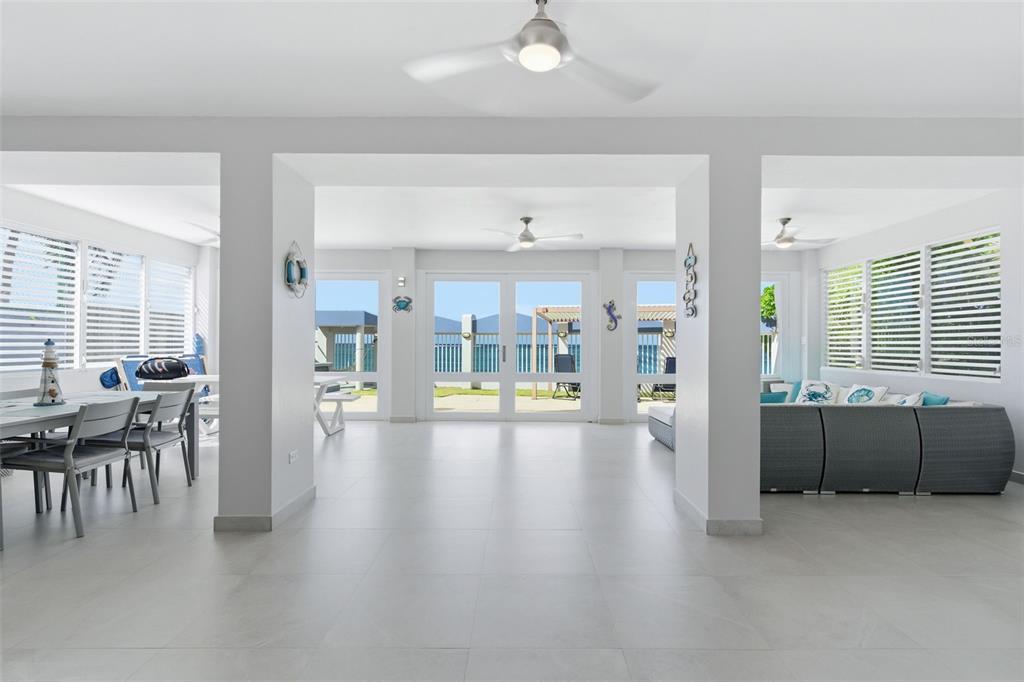 A bright, open-concept living and dining area features white tile floors and large glass doors — Carr. 690 LOTE #5 BO. CERRO GORDO, VEGA ALTA, PR