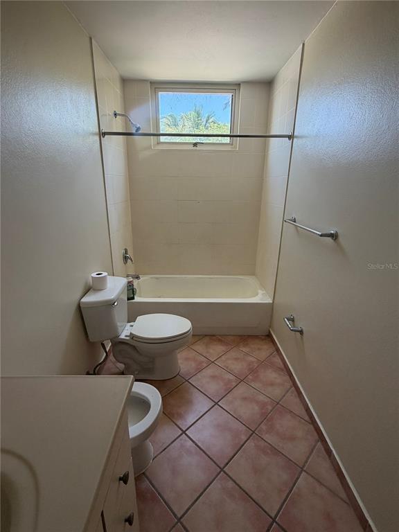 A bathroom features a tub-shower combination, a toilet, and terracotta-colored floor tiles — 6690 COND. COVE BY THE SEA UNIT C-201, VEGA ALTA, PR
