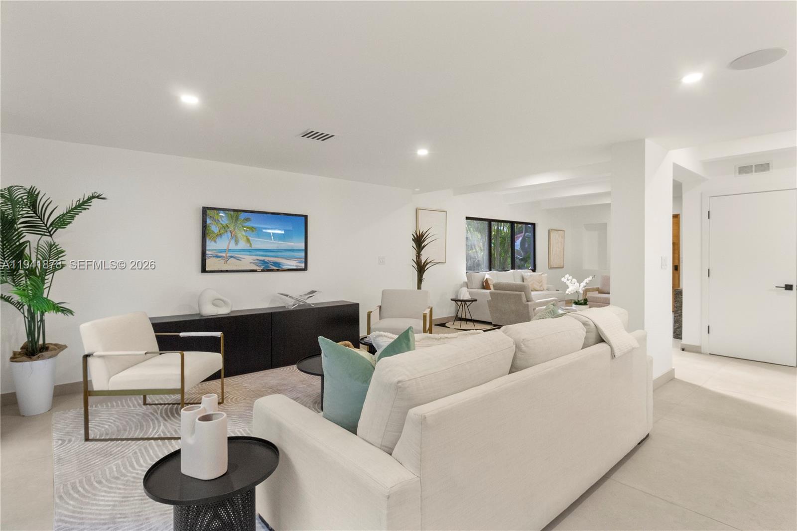 A modern living room features a white sofa, cream armchairs, and a black media console — 435 W 43rd St, Miami Beach FL 33140, MIAMI BEACH, FL