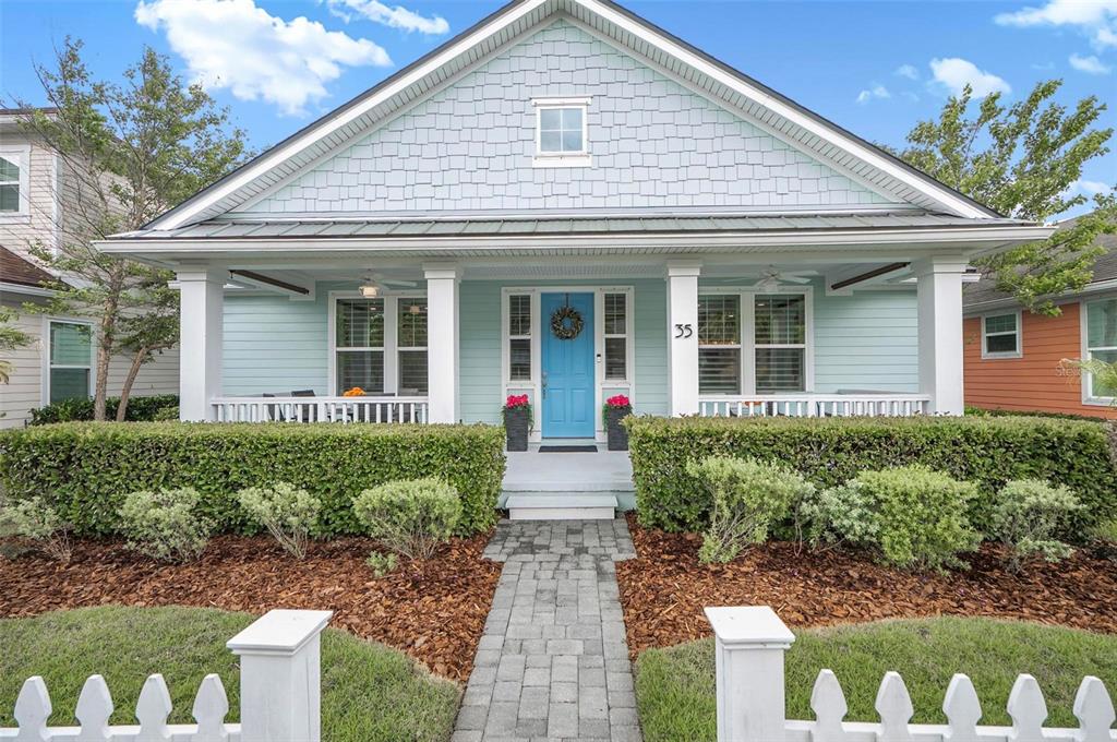 A light blue house with a front porch, white picket fence, and a blue door — 35 HIDDEN TREASURE DRIVE, PALM COAST, FL