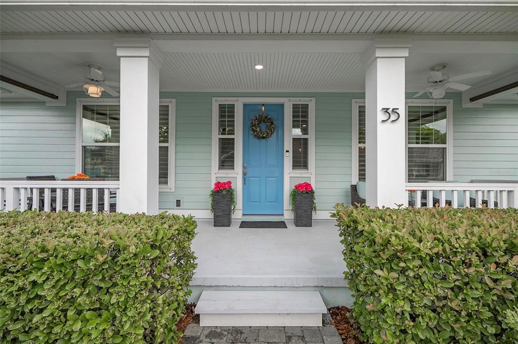 A front porch features a blue door, white columns, and green hedges — 35 HIDDEN TREASURE DRIVE, PALM COAST, FL