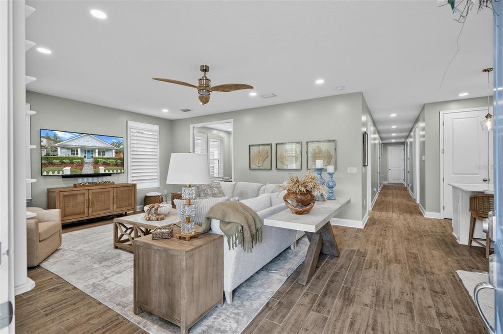 A living room features light gray walls, wood-look tile flooring, and a large sectional sofa — 35 HIDDEN TREASURE DRIVE, PALM COAST, FL