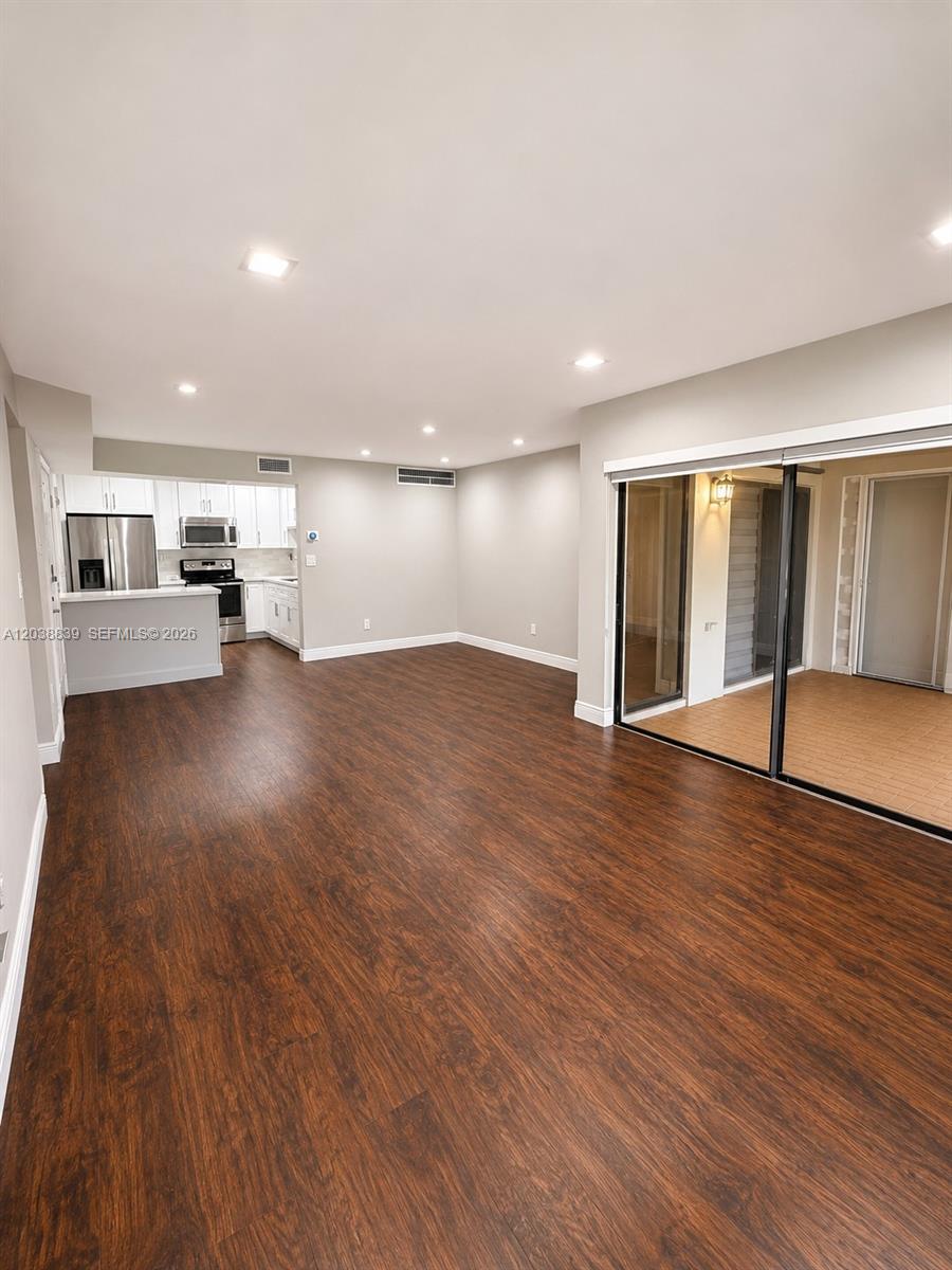 An open-concept living area features dark wood-look flooring, recessed lighting, and a kitchen pass-through — 20005 NE 3rd Ct # 8, Miami FL 33179, MIAMI, FL