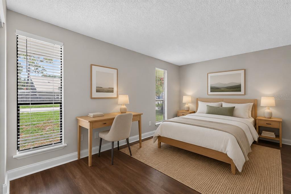 A bedroom with wood flooring, a bed, a desk, and two windows with blinds — 3918 PINE BREEZE ROAD S, JACKSONVILLE, FL