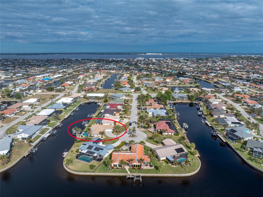 An aerial view shows a waterfront house with a pool and palm trees in Florida — 951 LASSINO COURT, PUNTA GORDA, FL
