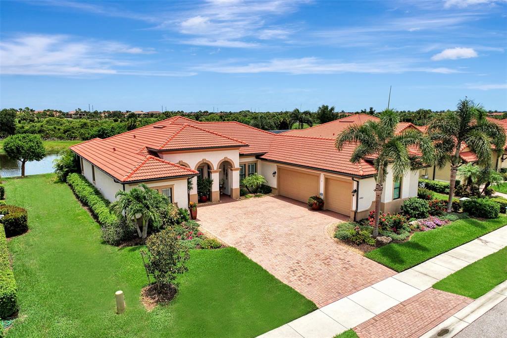 An aerial view of a single-story house with a red tile roof and brick driveway — 10965 BULLRUSH DRIVE, VENICE, FL