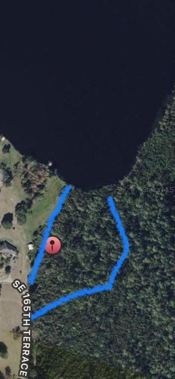 An aerial map shows a wooded, waterfront lot outlined in blue along a residential road — 165TH TERRACE ROAD, OCKLAWAHA, FL