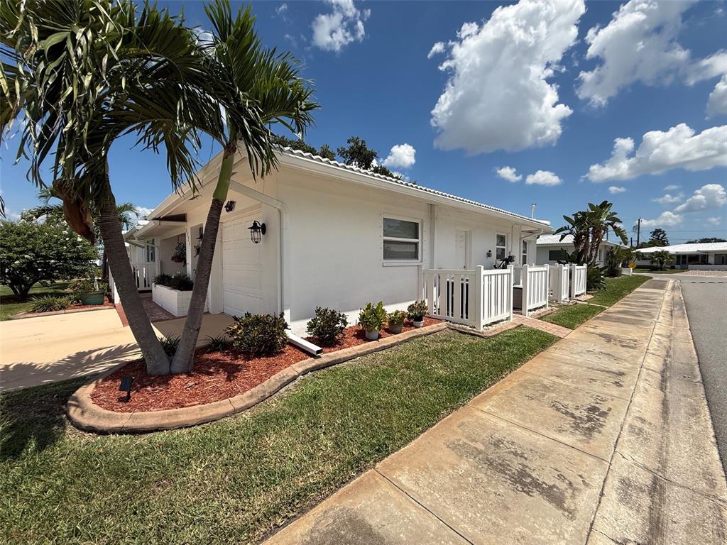 A white single-story house features a palm tree, a small lawn, and a concrete sidewalk — 4534 101ST AVENUE N, PINELLAS PARK, FL