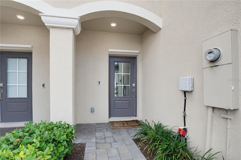 A paved walkway leads to the gray front door of a stucco home exterior — 15126 LYLA TERRACE, LAKEWOOD RANCH, FL