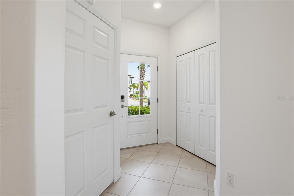 An entryway features light tile flooring, a white front door with a window, and closets — 15126 LYLA TERRACE, LAKEWOOD RANCH, FL