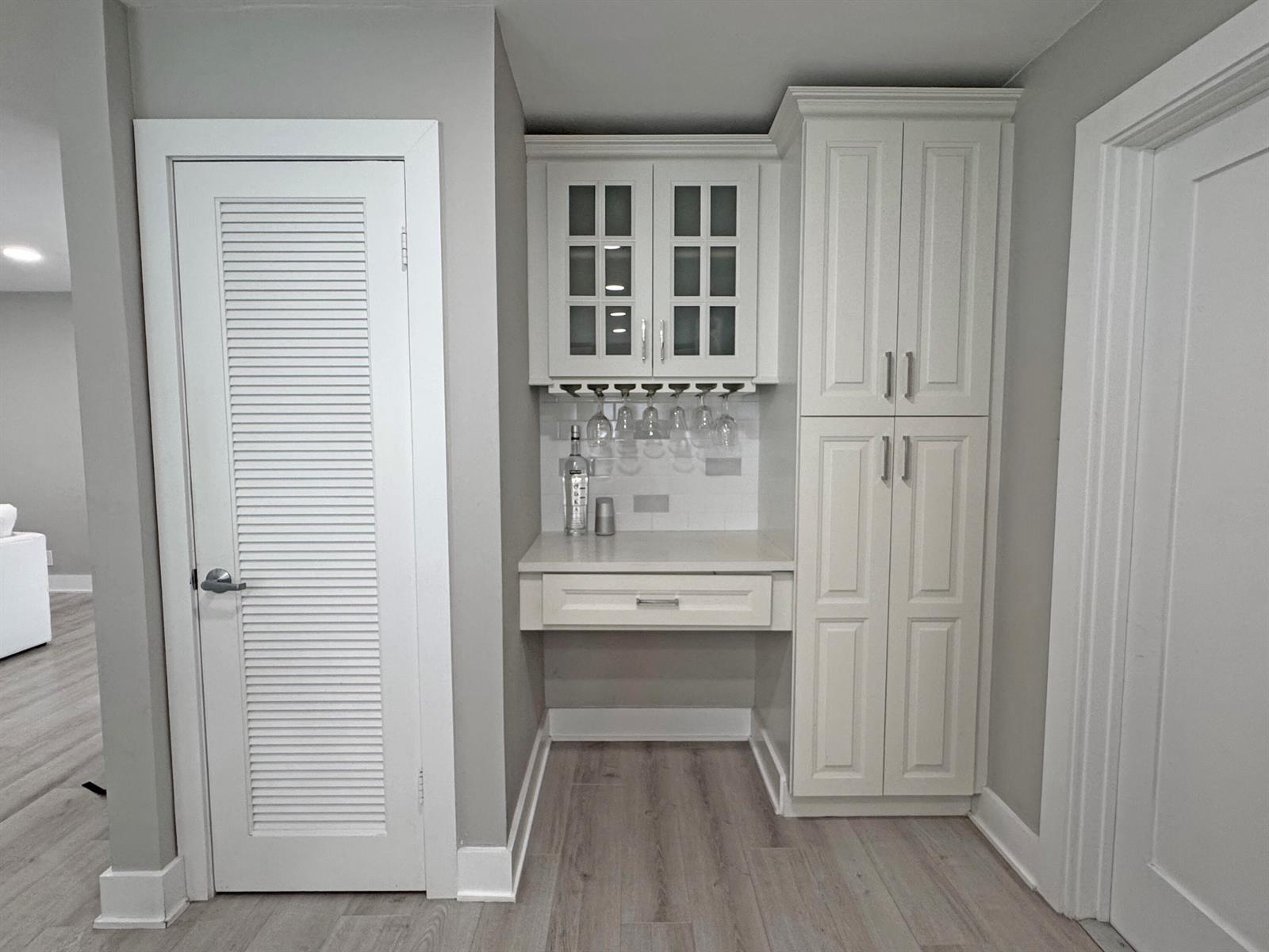 A built-in white bar area features glass-front cabinets, hanging stemware storage, and a drawer — 106 Periwinkle Drive, Hypoluxo FL 33462, HYPOLUXO, FL