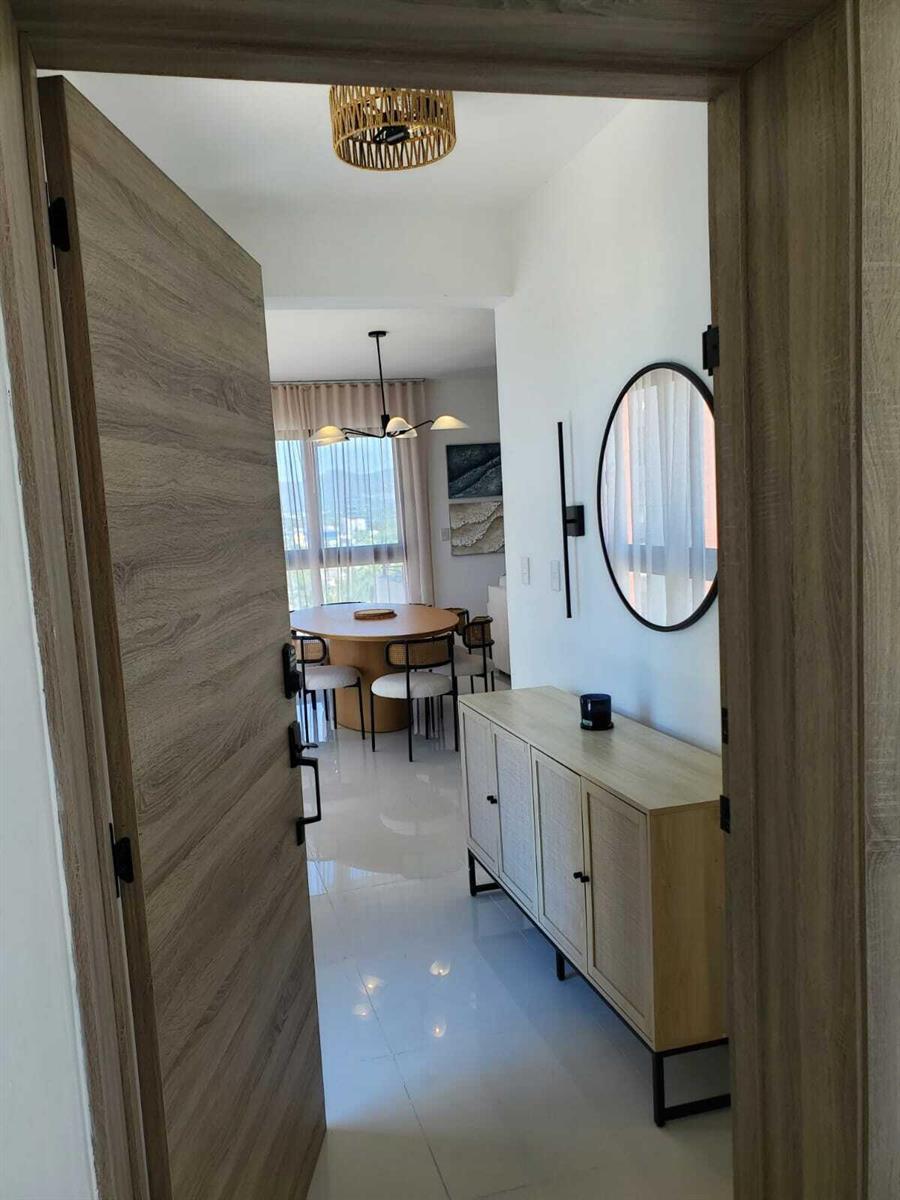 A view through a wooden doorway into a dining area with a round table and sideboard — 50 C. Los Fereira # I8, FL