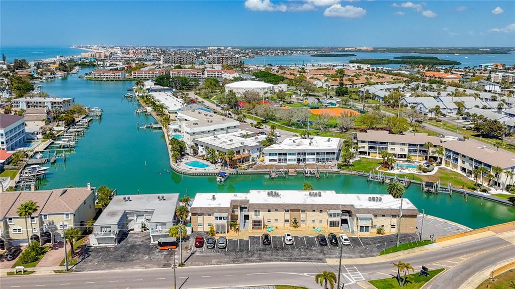 An aerial view shows a multi-story residential complex situated along a narrow canal — 184 117TH AVENUE UNIT 2, TREASURE ISLAND, FL