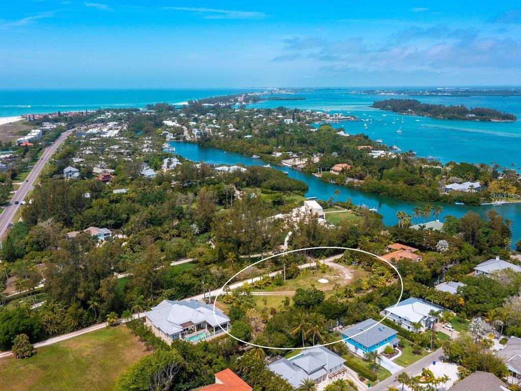 An aerial view shows a vacant, tree-lined residential lot circled in a coastal neighborhood — 6604-6608 GULF OF MEXICO DRIVE, LONGBOAT KEY, FL