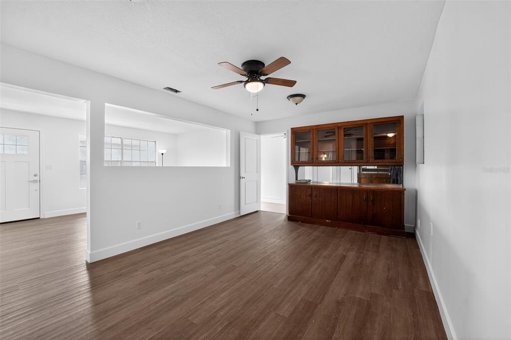 A room with wood-look flooring, a ceiling fan, and a built-in wooden hutch — 219 N EAST AVENUE, PANAMA CITY, FL