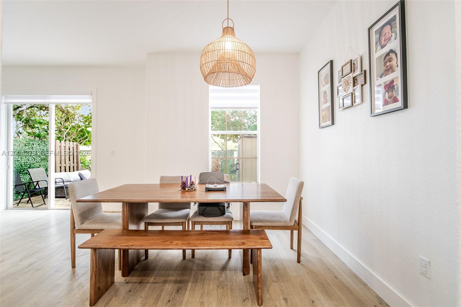 A dining room features a wooden table with a bench, chairs, and a rattan pendant light — 4414 Morgan Ln, Davie FL 33328, DAVIE, FL