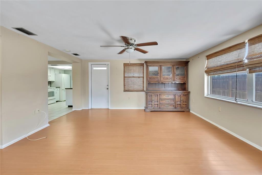 An empty room with light wood flooring, a ceiling fan, and a large wooden hutch — 3632 MORLEY DRIVE, NEW PORT RICHEY, FL