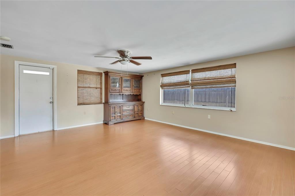 A living room features light wood flooring, a ceiling fan, and a large wooden hutch — 3632 MORLEY DRIVE, NEW PORT RICHEY, FL