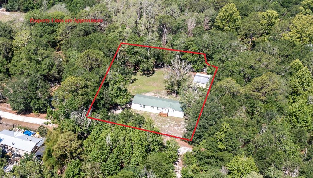 An aerial view shows a house and a detached garage on a wooded lot — 17824 NE 143RD TERRACE, WALDO, FL