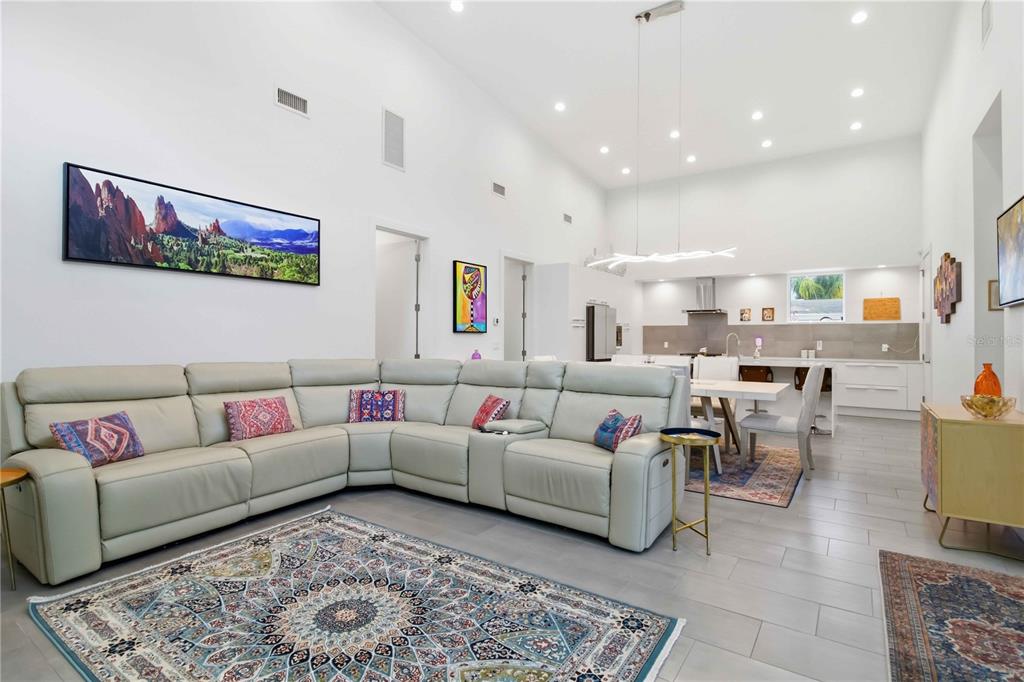 A spacious open-concept living room features a large sectional sofa, high ceilings, and tile flooring — 2373 PROSPECT STREET, SARASOTA, FL