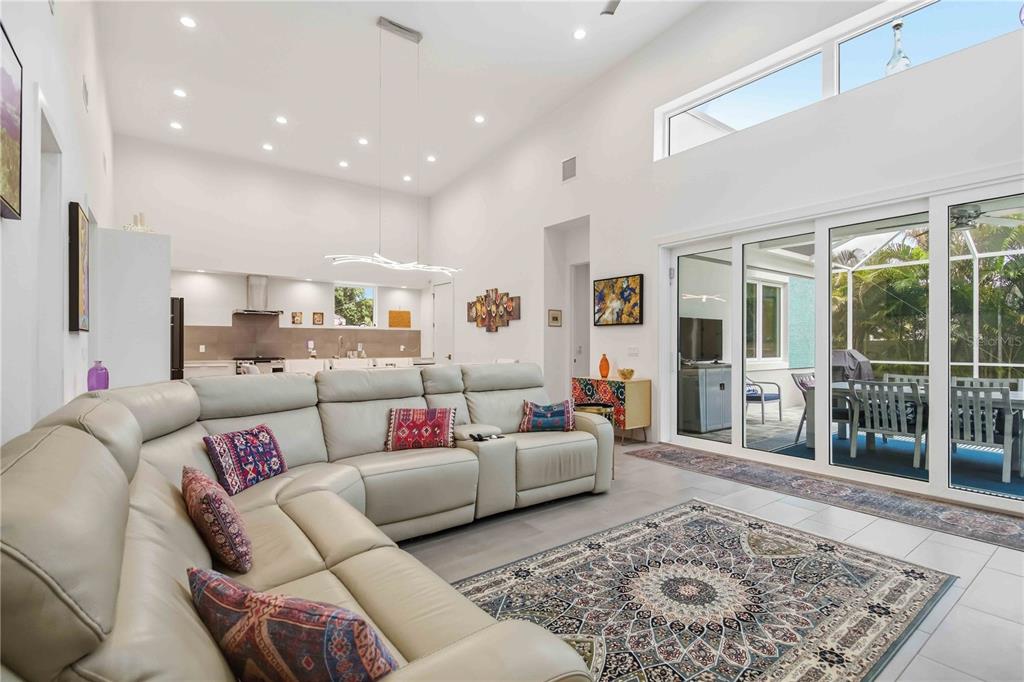 A spacious living room with a sectional sofa, high ceilings, and sliding glass doors — 2373 PROSPECT STREET, SARASOTA, FL