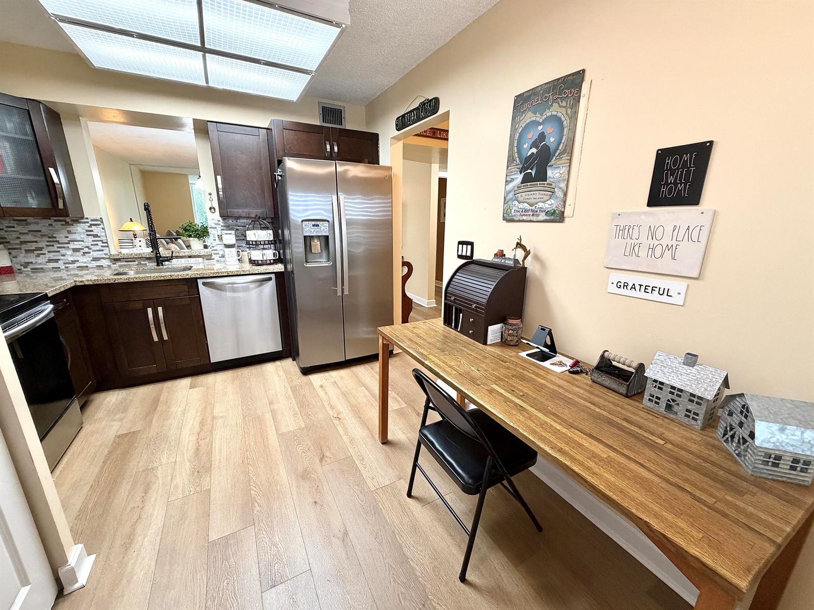 A kitchen features dark wood cabinets, stainless steel appliances, and a long wooden desk area — 7320 Lake Cir Drive # 204, Margate FL 33063, MARGATE, FL