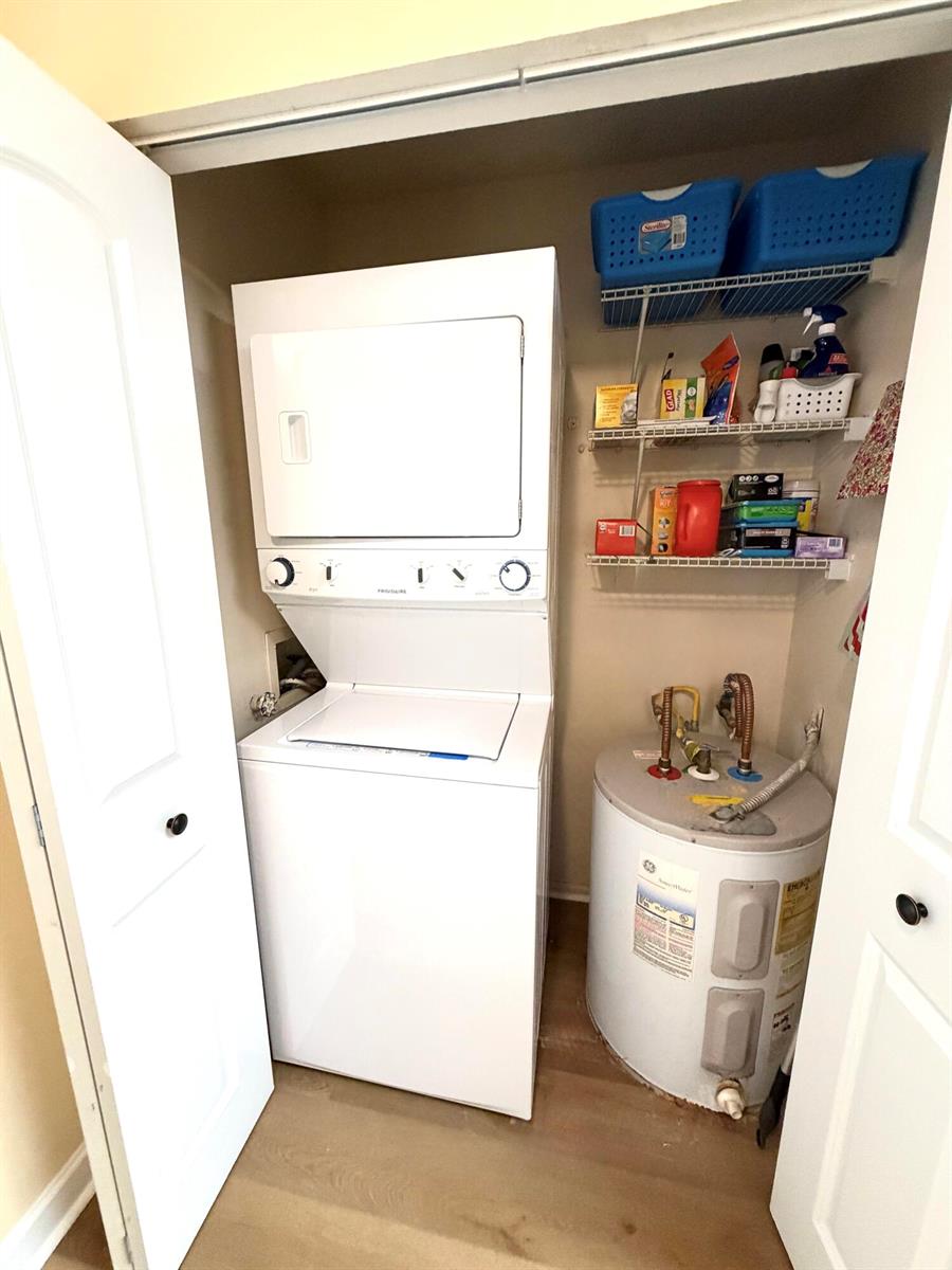 A laundry closet contains a stacked washer-dryer unit, a water heater, and wire shelving — 7320 Lake Cir Drive # 204, Margate FL 33063, MARGATE, FL
