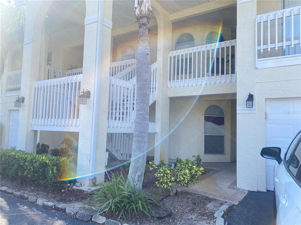 A two-story building exterior features white railings, a palm tree, and a paved driveway — 3204 SABAL PALMS COURT UNIT B, KISSIMMEE, FL