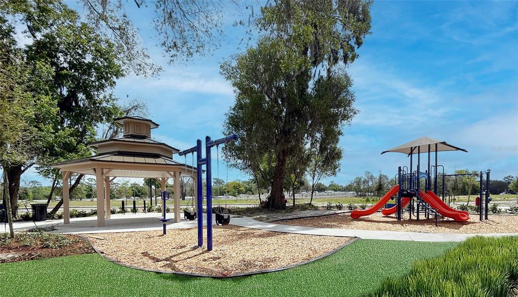 A playground features a gazebo, a swing set, and a slide structure on wood chips — 2031 ANTHEM DRIVE, ORANGE CITY, FL