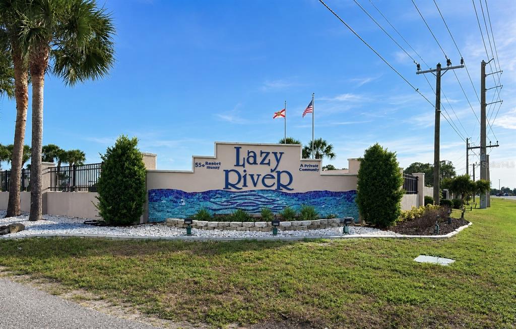 The exterior entrance sign for a 55+ resort community features a blue mosaic base — 216 MARTINIQUE ROAD, NORTH PORT, FL